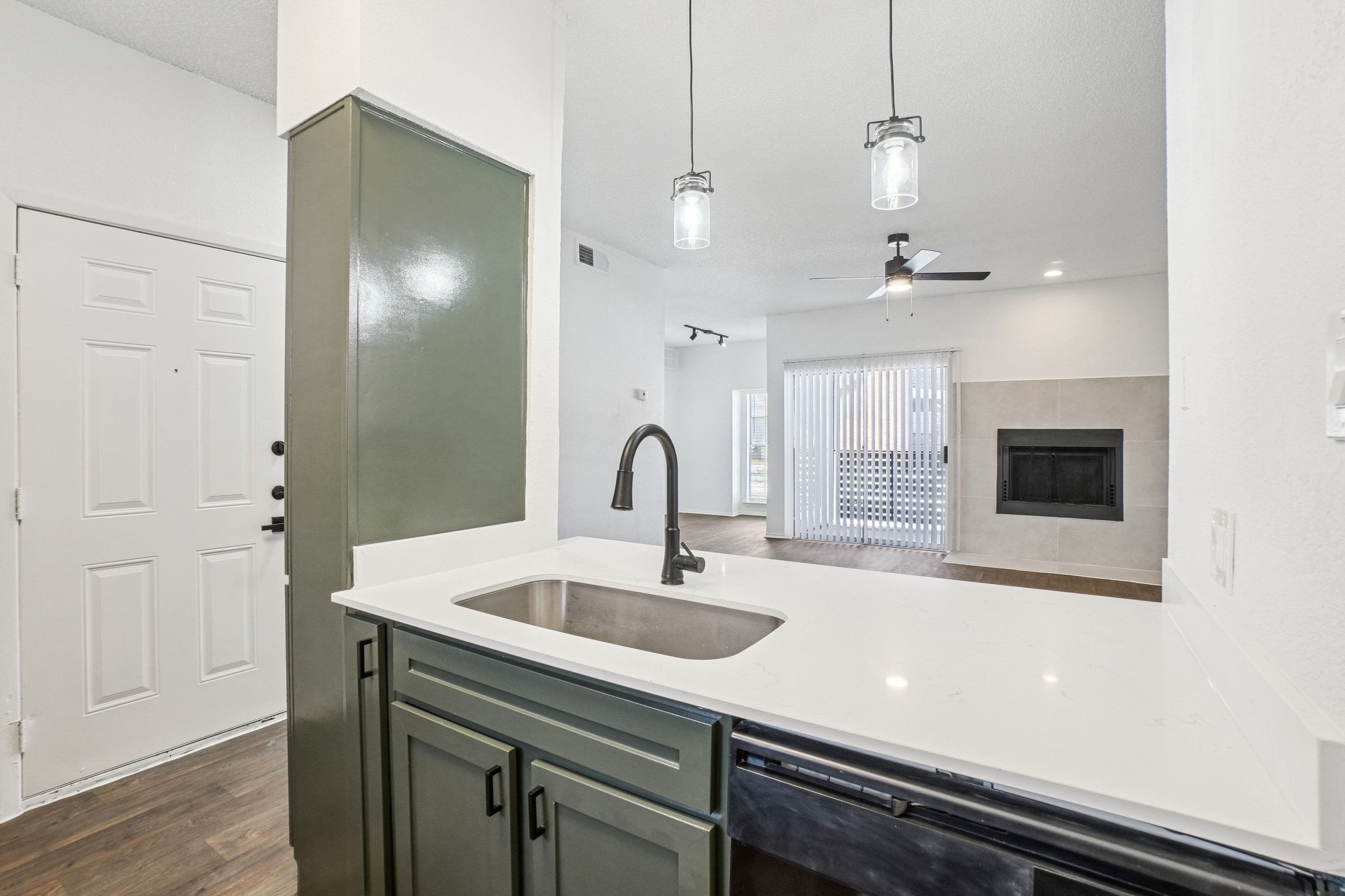 A kitchen with a sink and a green cabinet.